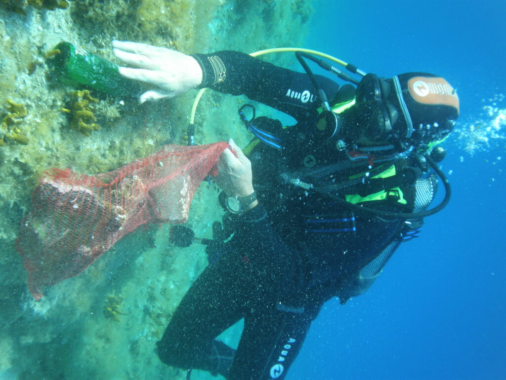 Un volontaire ramasse des déchets plastiques sous marin